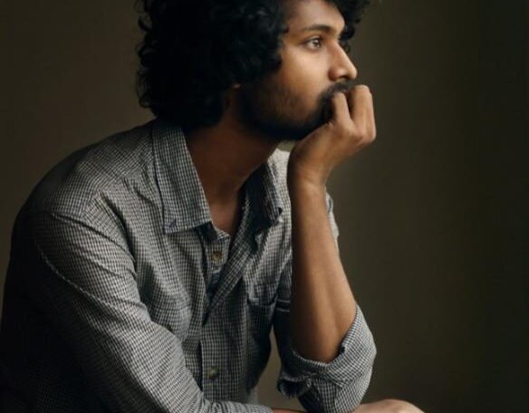 Thoughtful man sitting with his chin resting on his hand, looking away in a quiet, reflective moment